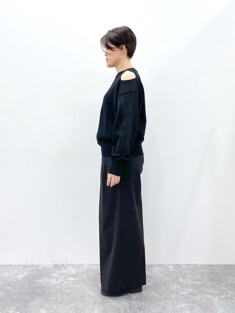 ブラック系のニット/セーター、ブラック系のスラックスを着用したレディースの春コーディネートの7枚目の写真