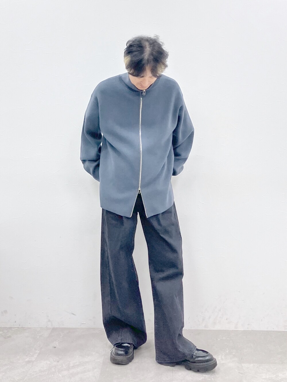 ブラック系のダウンジャケット/コート、グレー系のカーディガン/ボレロ、ブラック系のデニムパンツを着用したメンズの秋コーディネートの8枚目の写真