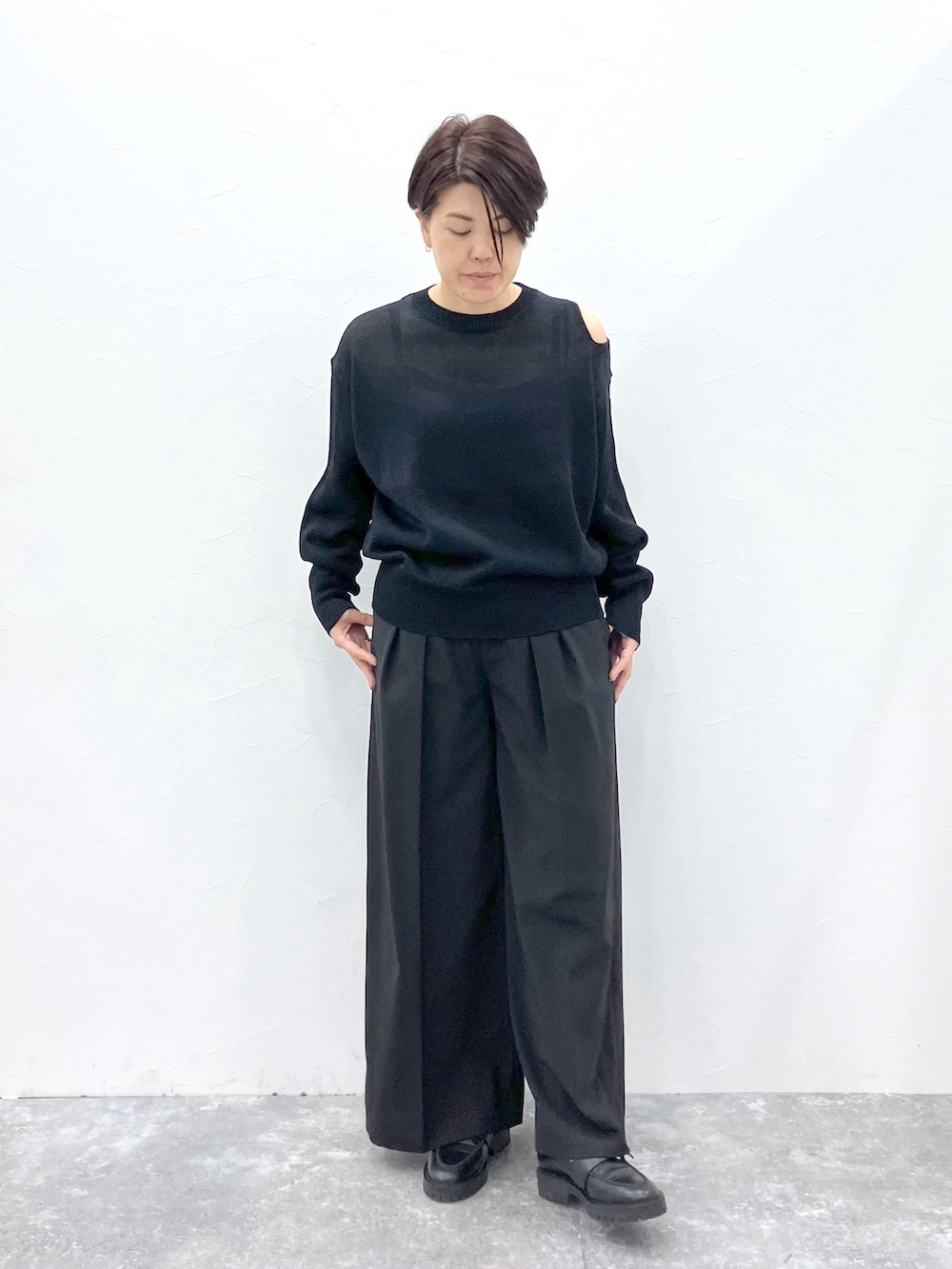 ブラック系のニット/セーター、ブラック系のスラックスを着用したレディースの春コーディネートの2枚目の写真