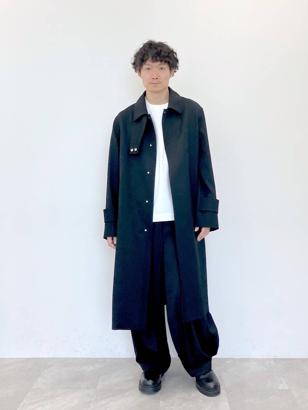 ブラック系のその他パンツ、ブラック系のステンカラーコートを着用したメンズの秋コーディネートの3枚目の写真