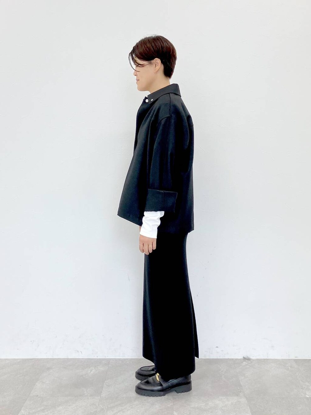 ブラック系のその他アウター、ホワイト系のTシャツ/カットソー、ブラック系のスカートを着用したレディースの秋コーディネートの6枚目の写真