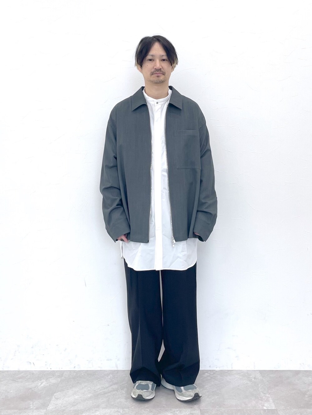 グレー系のブルゾン、ホワイト系のシャツ/ブラウス、ブラック系のスラックスを着用したメンズの冬コーディネートの6枚目の写真