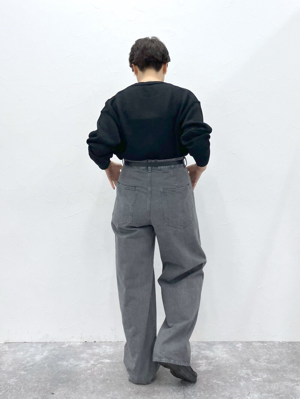 ブラック系のニット/セーター、グレー系のデニムパンツを着用したレディースの春コーディネートの3枚目の写真