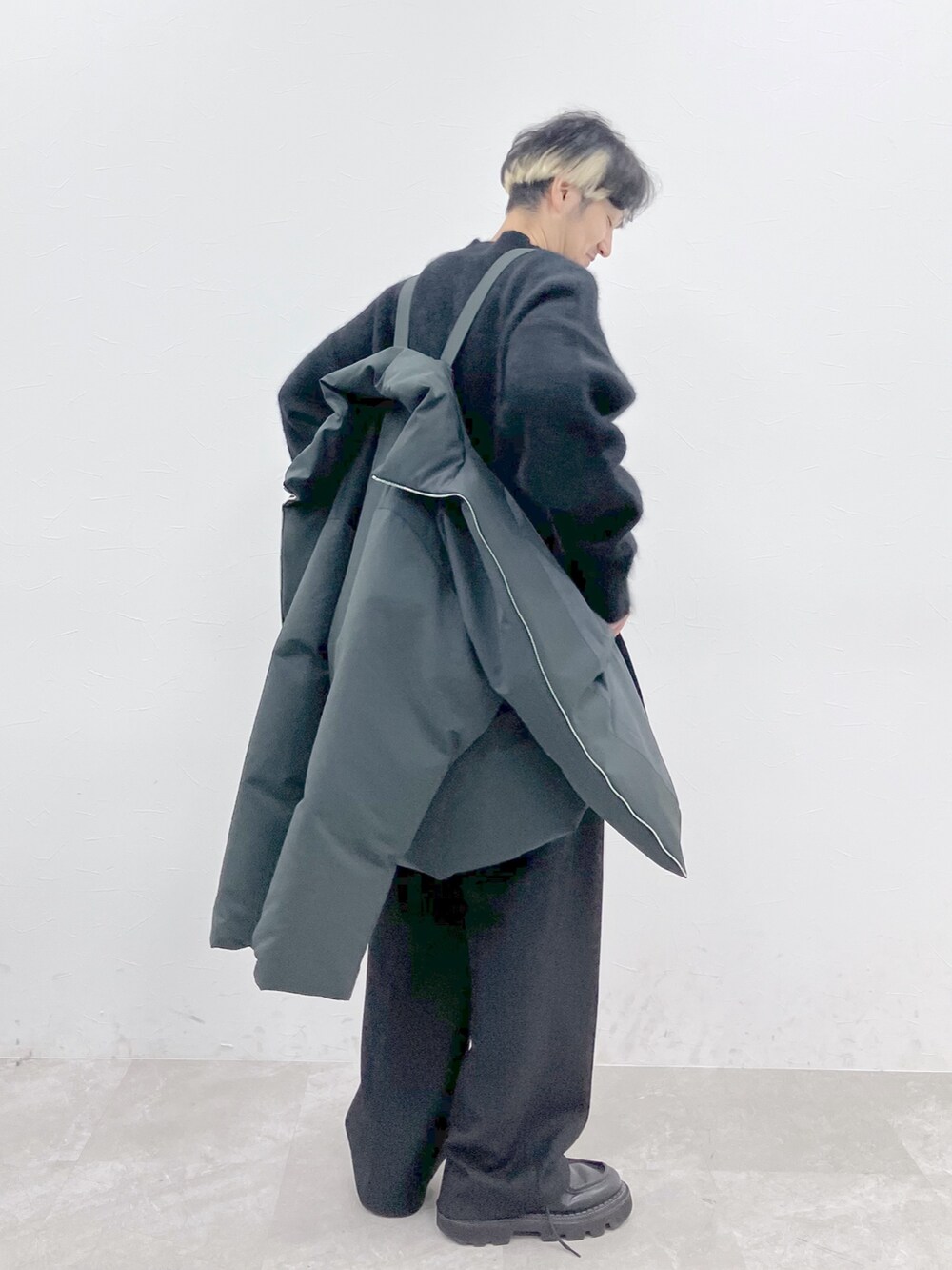 グレー系のダウンジャケット/コート、ブラック系のニット/セーター、ブラック系のその他パンツを着用したメンズの秋コーディネートの8枚目の写真