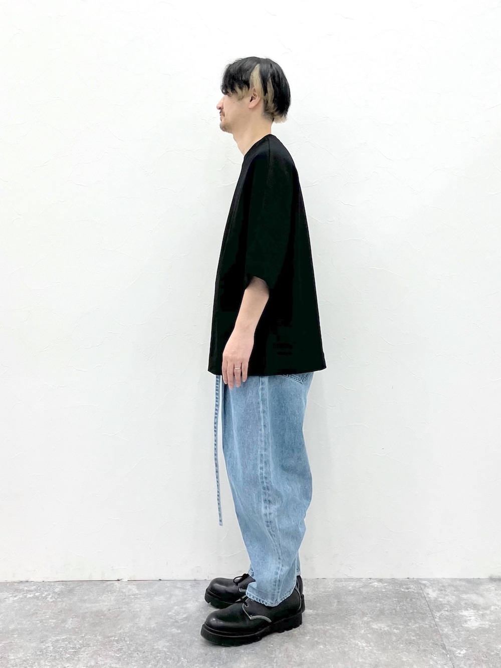 ブラック系のTシャツ/カットソー、ブルー系のデニムパンツを着用したメンズの春コーディネートの6枚目の写真