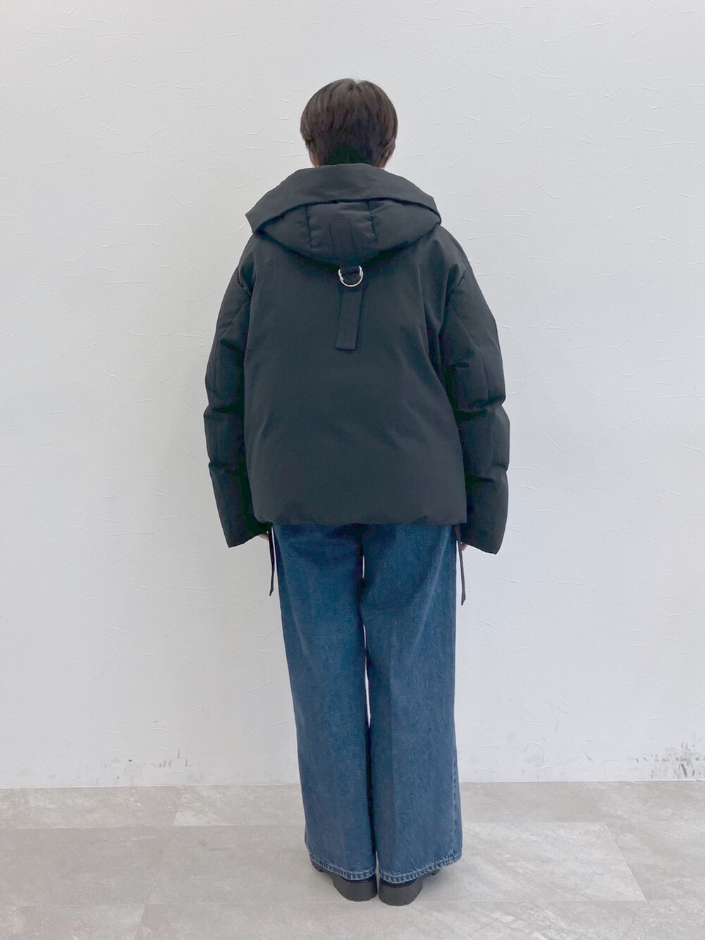 ブラック系のダウンジャケット/コート、ホワイト系のTシャツ/カットソー、ブルー系のデニムパンツを着用したレディースの秋コーディネートの7枚目の写真