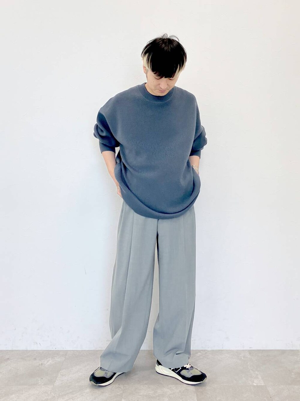グレー系のニット/セーター、グレー系のスラックス、グレー系のスラックスを着用したメンズの秋コーディネートの2枚目の写真