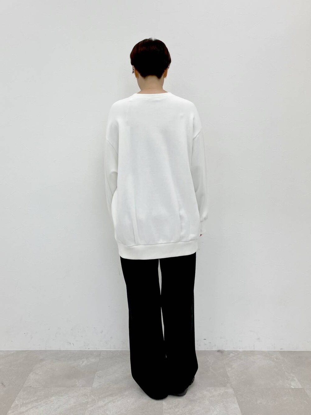 ホワイト系のスウェット、ブラック系のスラックス、ブラック系のその他パンツを着用したレディースの秋コーディネートの8枚目の写真