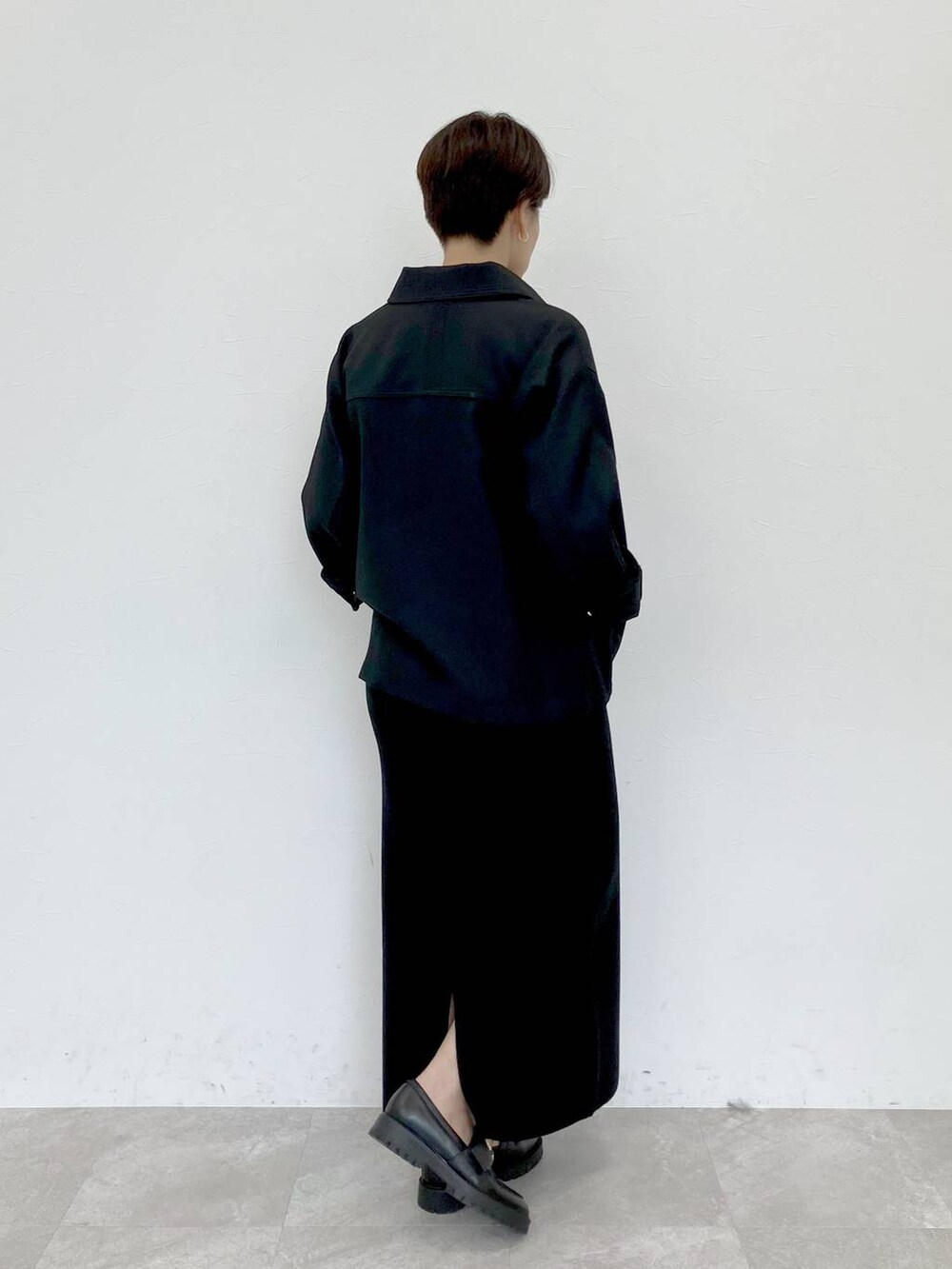 ブラック系のその他アウター、ホワイト系のTシャツ/カットソー、ブラック系のスカートを着用したレディースの秋コーディネートの3枚目の写真