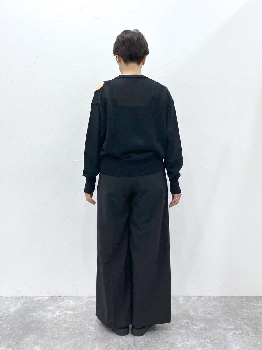 ブラック系のニット/セーター、ブラック系のスラックスを着用したレディースの春コーディネートの8枚目の写真