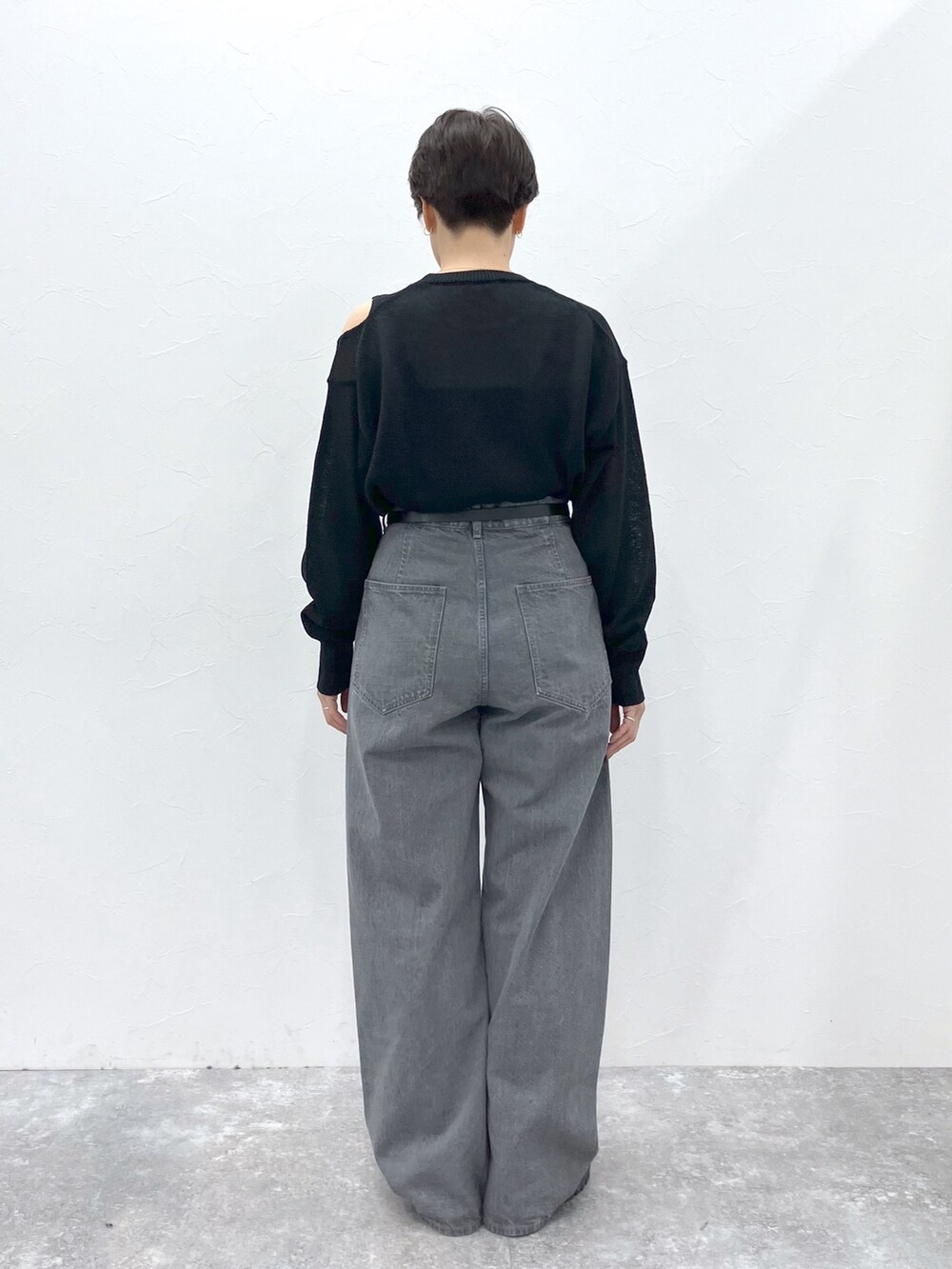 ブラック系のニット/セーター、グレー系のデニムパンツを着用したレディースの春コーディネートの7枚目の写真