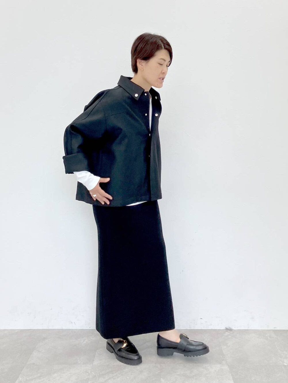 ブラック系のその他アウター、ホワイト系のTシャツ/カットソー、ブラック系のスカートを着用したレディースの秋コーディネートの4枚目の写真