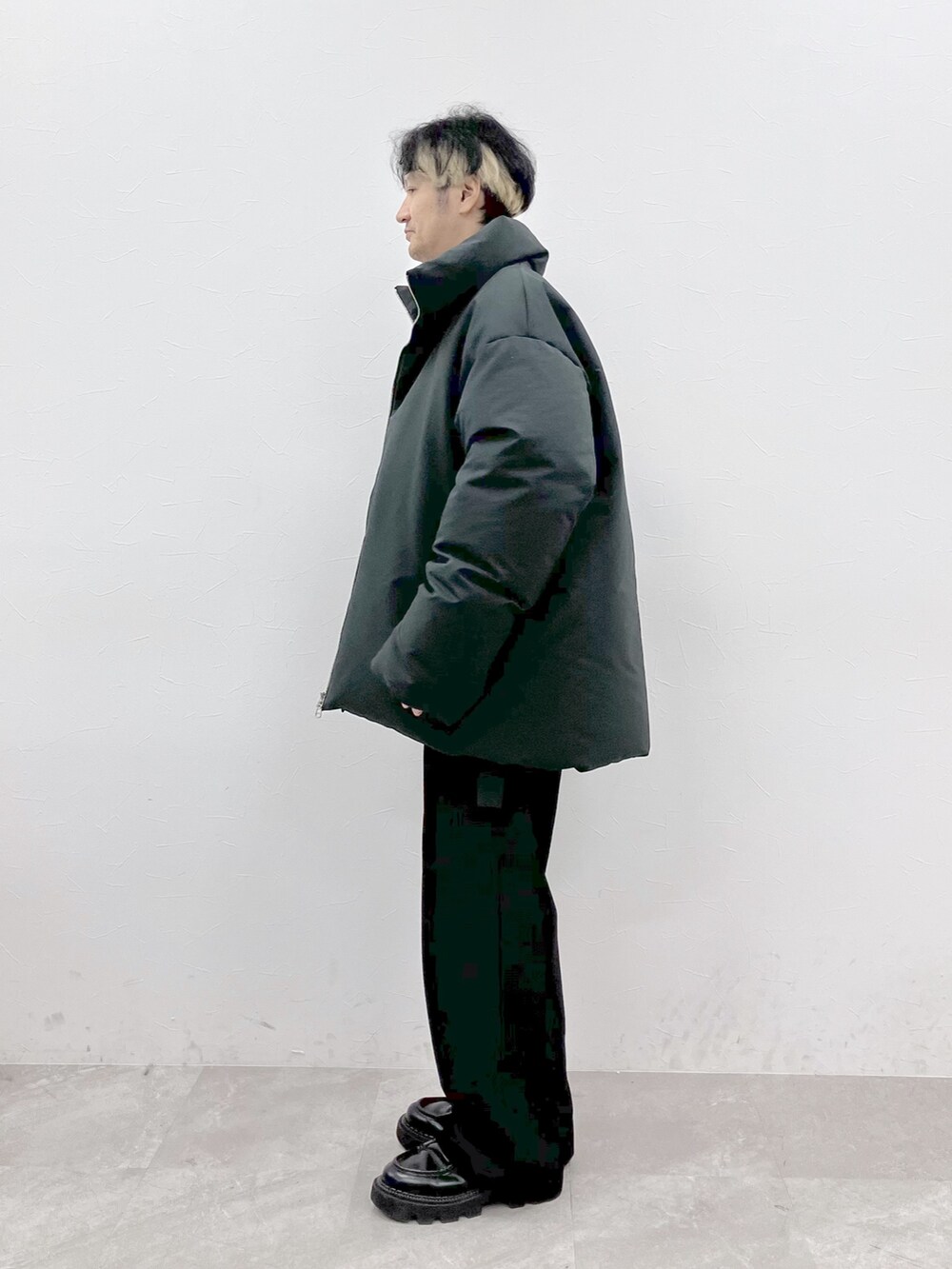 グレー系のダウンジャケット/コート、ブラック系のニット/セーター、ブラック系のその他パンツを着用したメンズの秋コーディネートの5枚目の写真