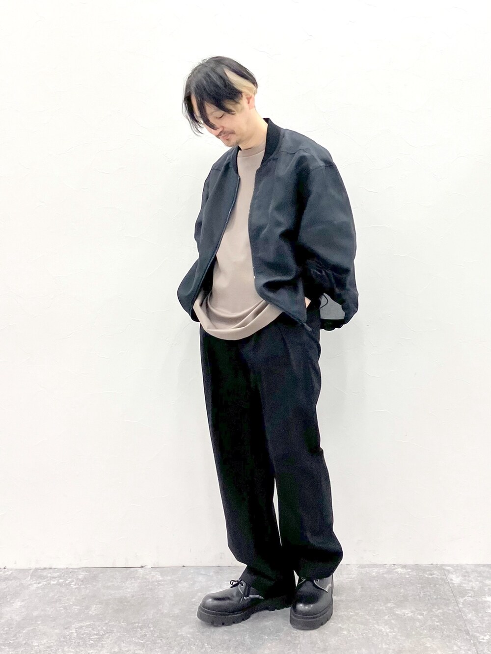 ブラック系のMA-1、ブラウン系のTシャツ/カットソー、ブラック系のスラックスを着用したメンズの春コーディネートの5枚目の写真