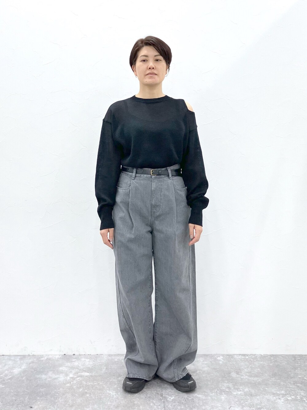 ブラック系のニット/セーター、グレー系のデニムパンツを着用したレディースの春コーディネートの5枚目の写真