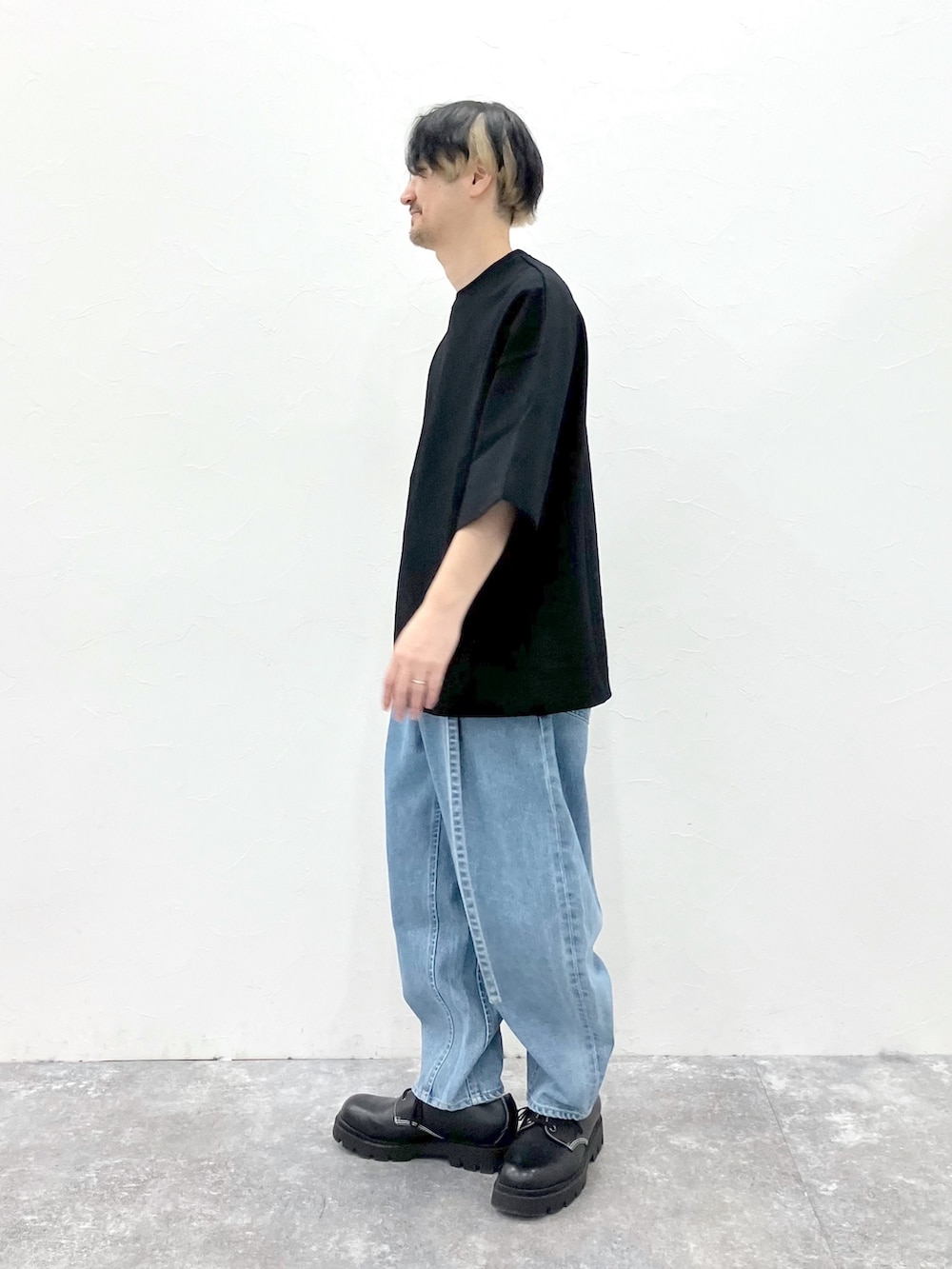 ブラック系のTシャツ/カットソー、ブルー系のデニムパンツを着用したメンズの春コーディネートの4枚目の写真