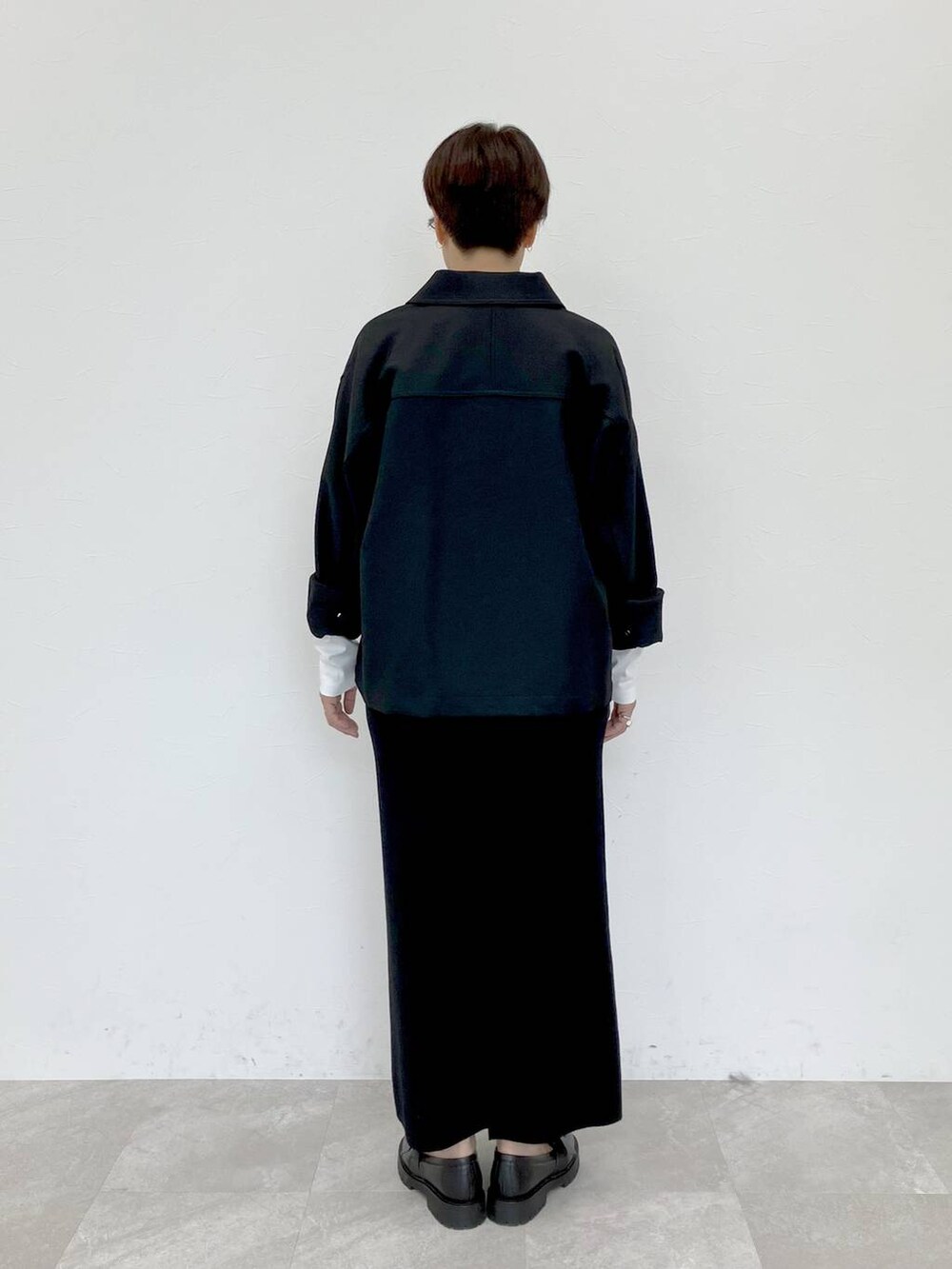 ブラック系のその他アウター、ホワイト系のTシャツ/カットソー、ブラック系のスカートを着用したレディースの秋コーディネートの7枚目の写真