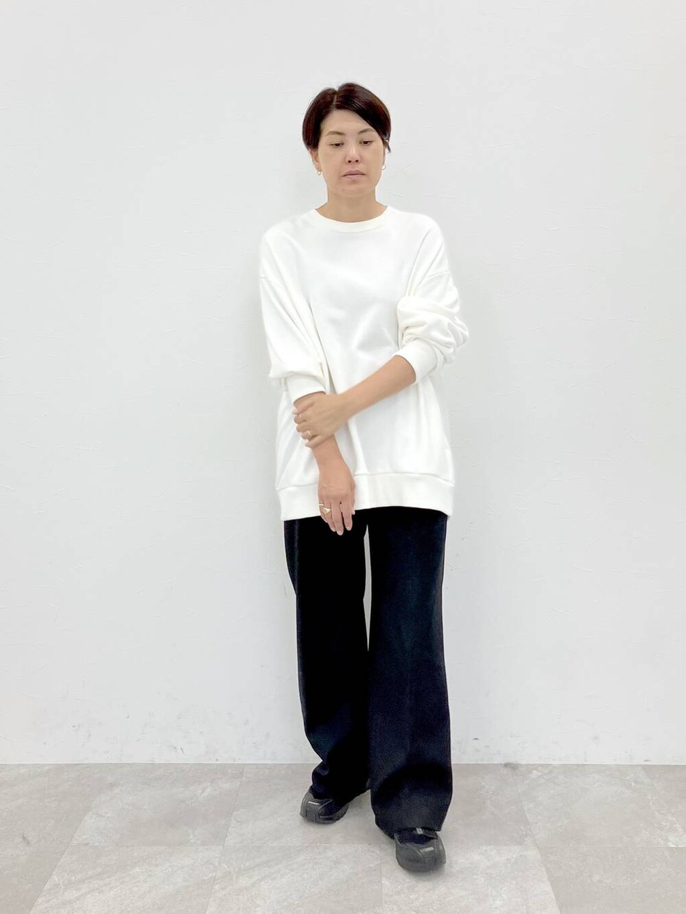 ホワイト系のスウェット、ブラック系のスラックス、ブラック系のその他パンツを着用したレディースの秋コーディネートの4枚目の写真