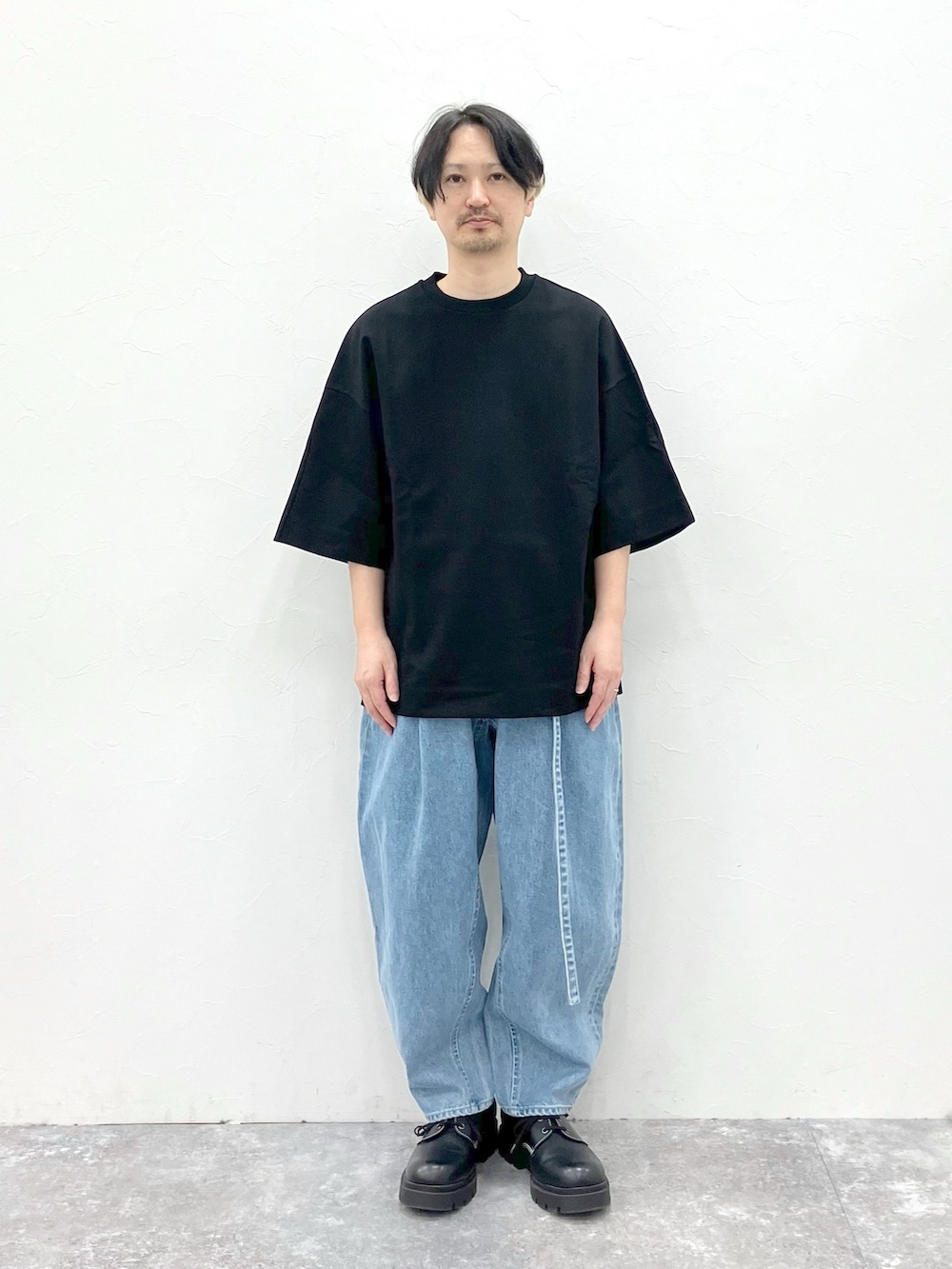 ブラック系のTシャツ/カットソー、ブルー系のデニムパンツを着用したメンズの春コーディネートの5枚目の写真