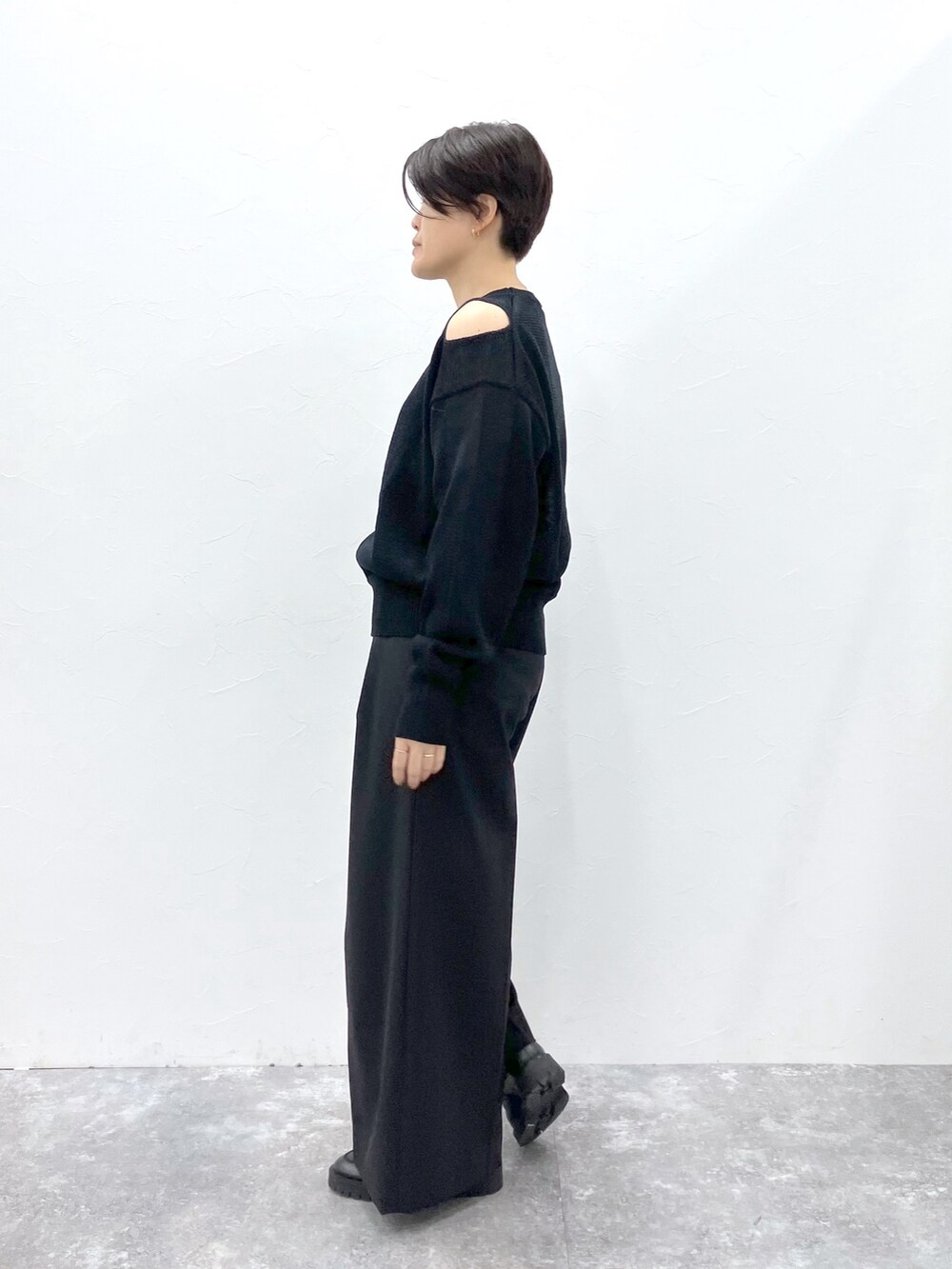 ブラック系のニット/セーター、ブラック系のスラックスを着用したレディースの春コーディネートの3枚目の写真