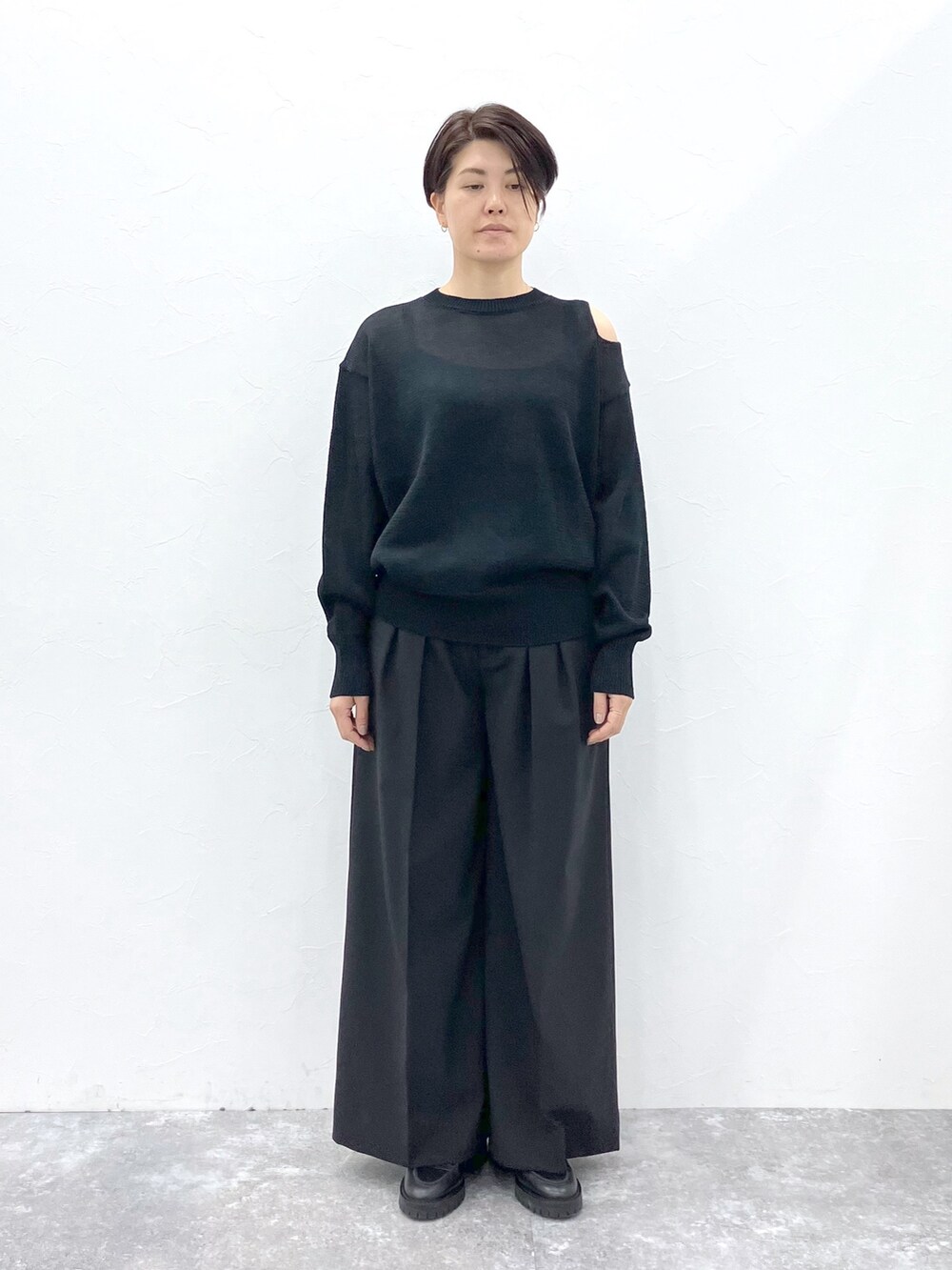 ブラック系のニット/セーター、ブラック系のスラックスを着用したレディースの春コーディネートの6枚目の写真