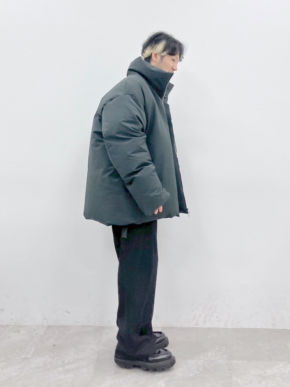 グレー系のダウンジャケット/コート、ブラック系のニット/セーター、ブラック系のその他パンツを着用したメンズの秋コーディネートの3枚目の写真