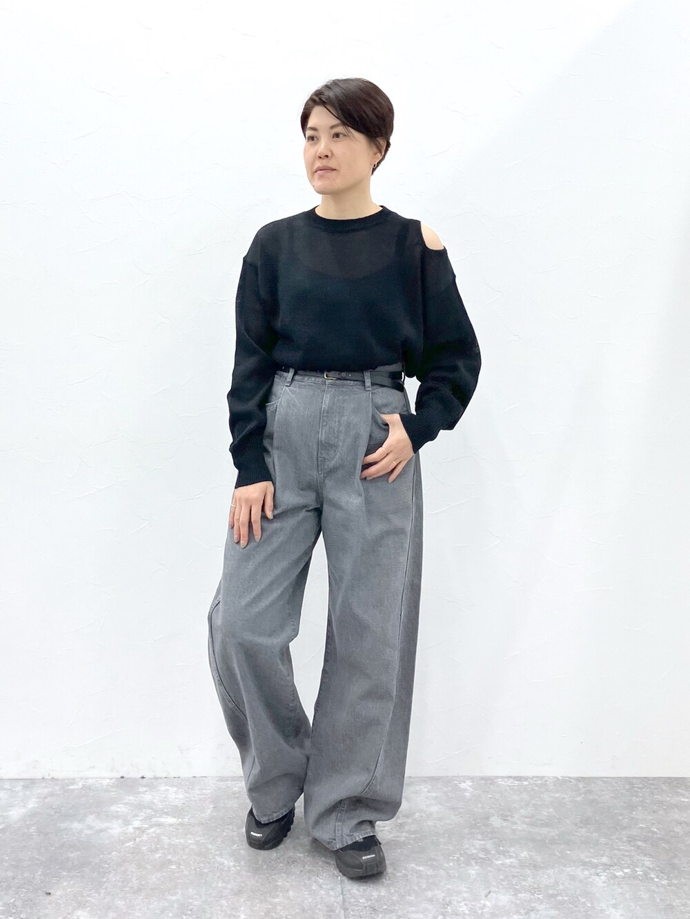 ブラック系のニット/セーター、グレー系のデニムパンツを着用したレディースの春コーディネートの4枚目の写真