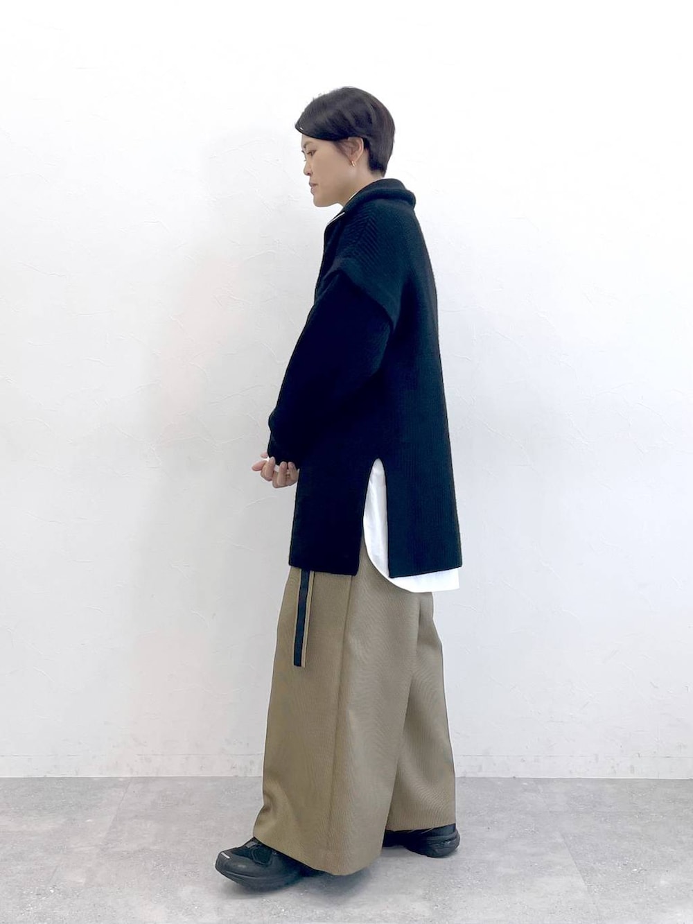 ホワイト系のシャツ/ブラウス、ベージュ系のスラックス、ブラック系のニット/セーターを着用したレディースの秋コーディネートの2枚目の写真