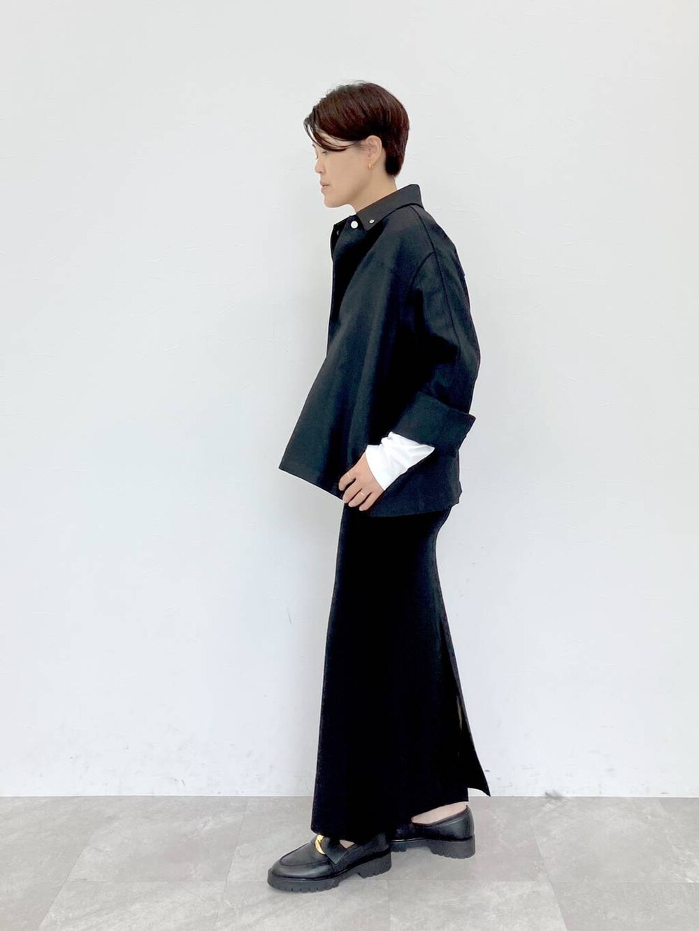 ブラック系のその他アウター、ホワイト系のTシャツ/カットソー、ブラック系のスカートを着用したレディースの秋コーディネートの2枚目の写真