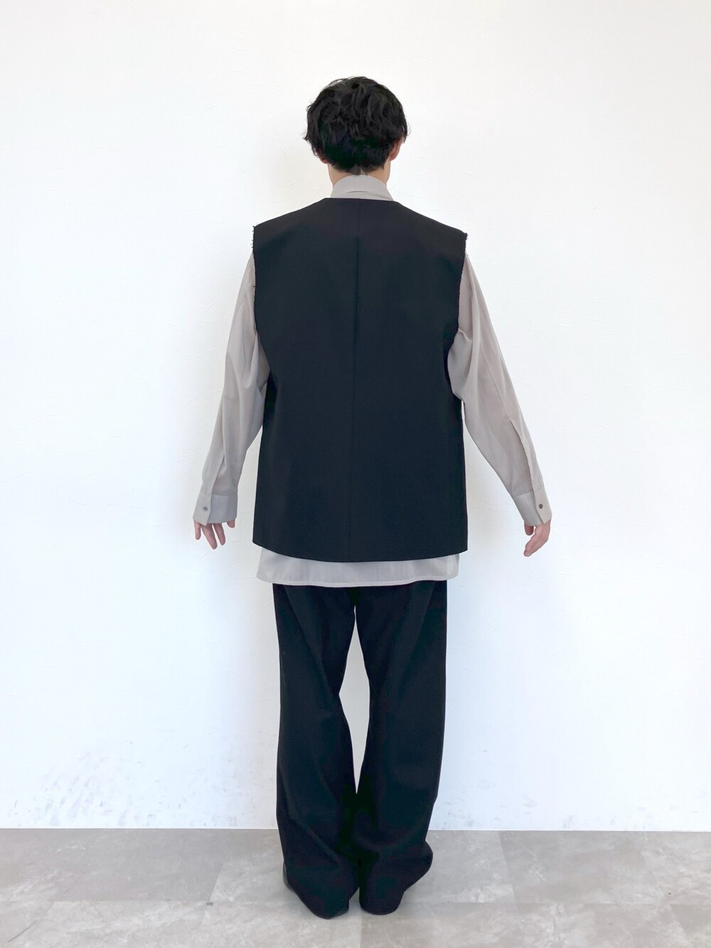 ブラック系のベスト、ベージュ系のシャツ/ブラウス、ブラック系のスラックスを着用したメンズの春コーディネートの7枚目の写真