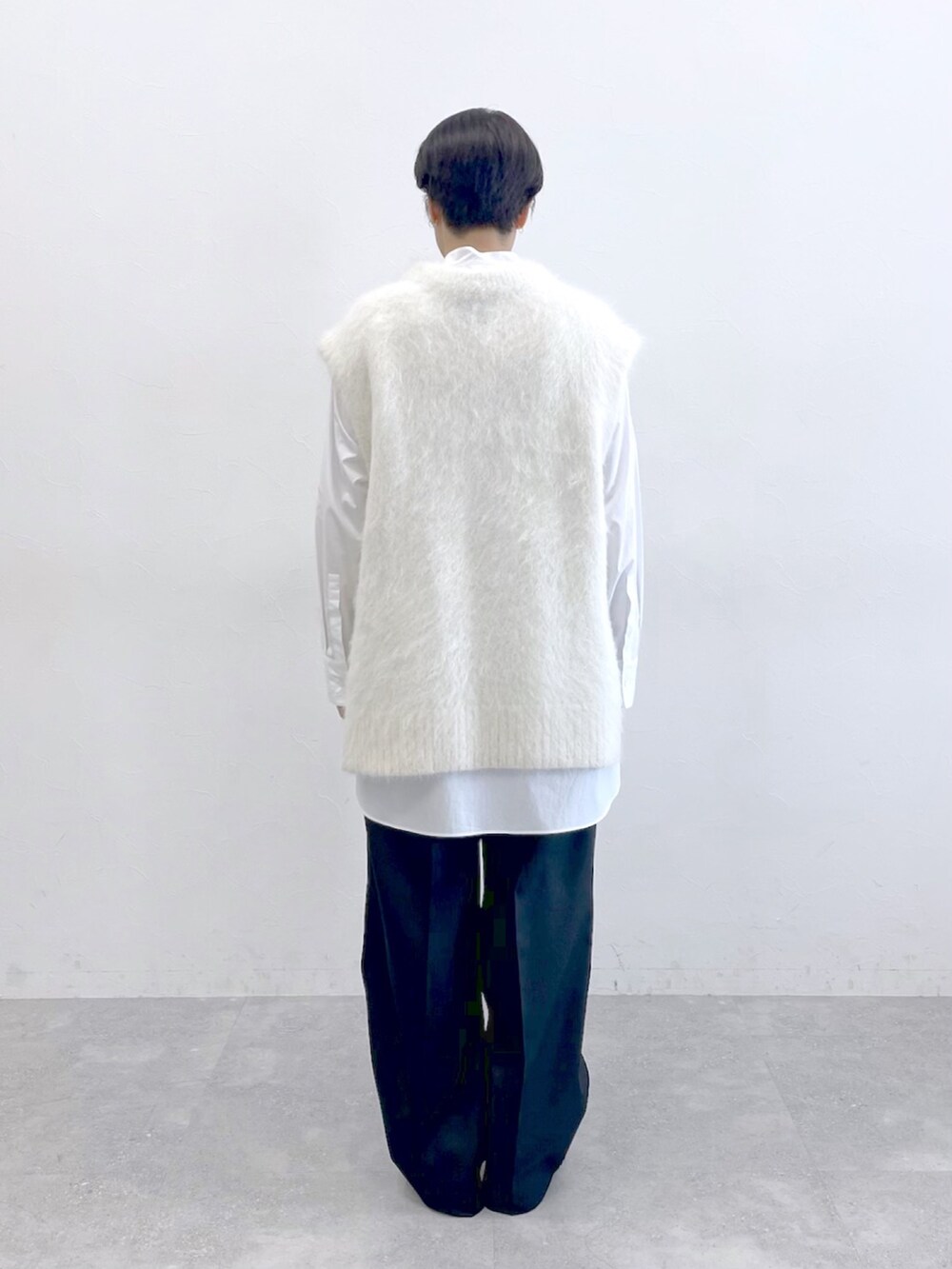 ホワイト系のニット/セーター、ホワイト系のシャツ/ブラウス、ブラック系のスラックスを着用したレディースの冬コーディネートの8枚目の写真