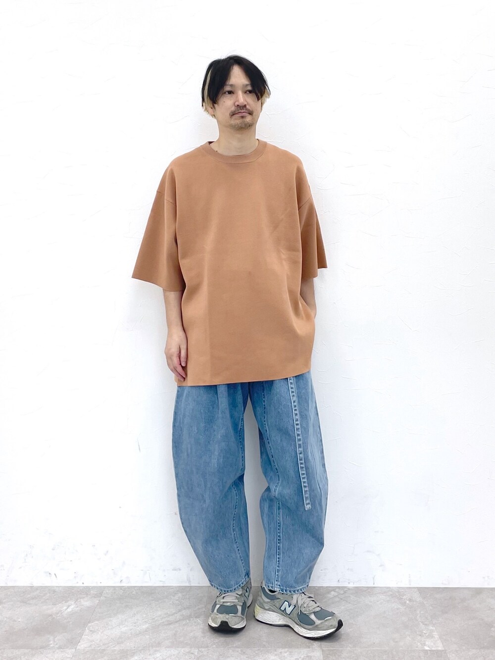 ブラック系のブルゾン、ベージュ系のトップス、ブルー系のデニムパンツを着用したメンズの冬コーディネートの3枚目の写真