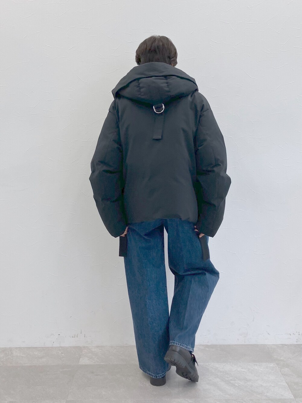 ブラック系のダウンジャケット/コート、ホワイト系のTシャツ/カットソー、ブルー系のデニムパンツを着用したレディースの秋コーディネートの3枚目の写真