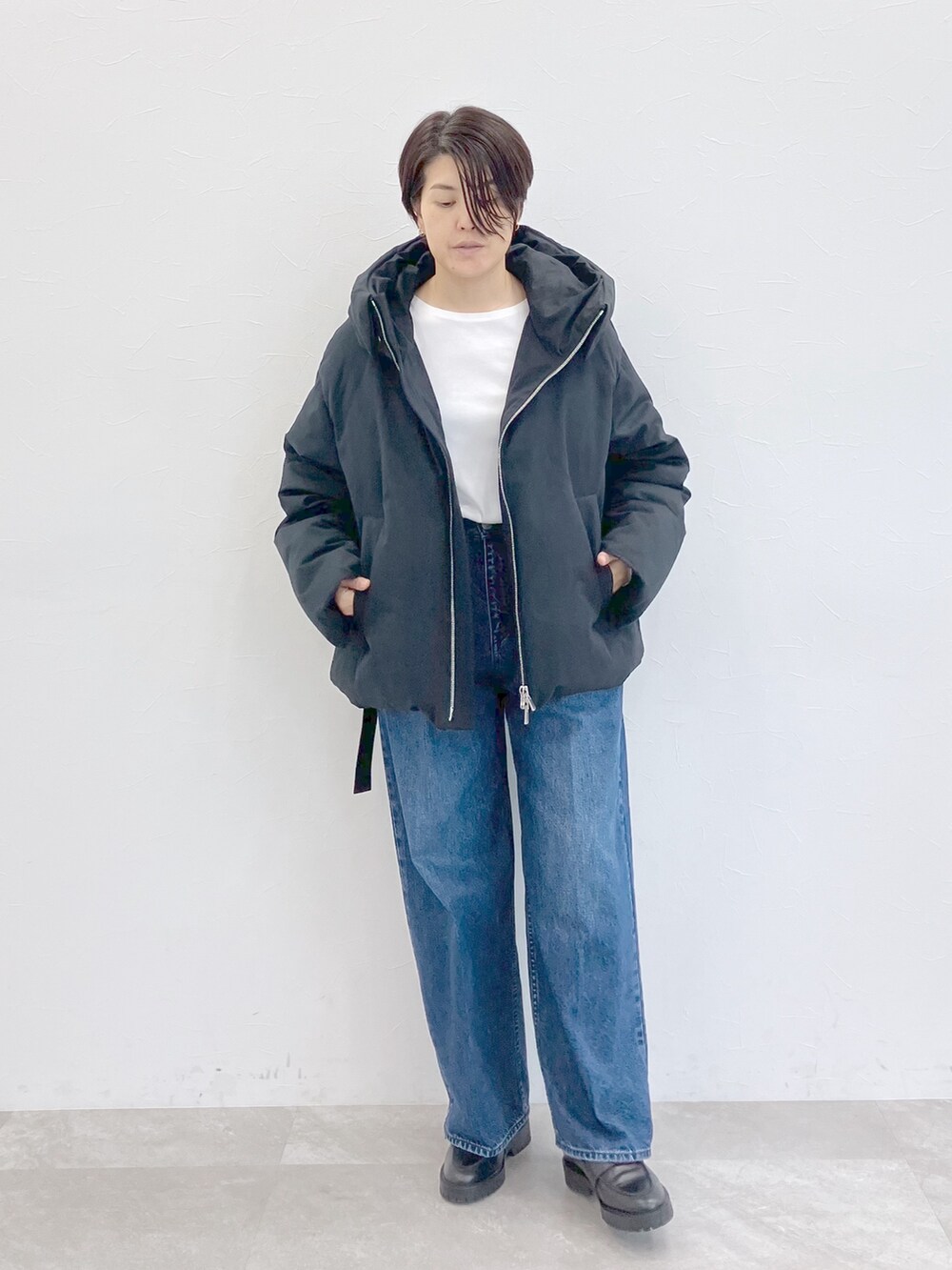 ブラック系のダウンジャケット/コート、ホワイト系のTシャツ/カットソー、ブルー系のデニムパンツを着用したレディースの秋コーディネートの4枚目の写真