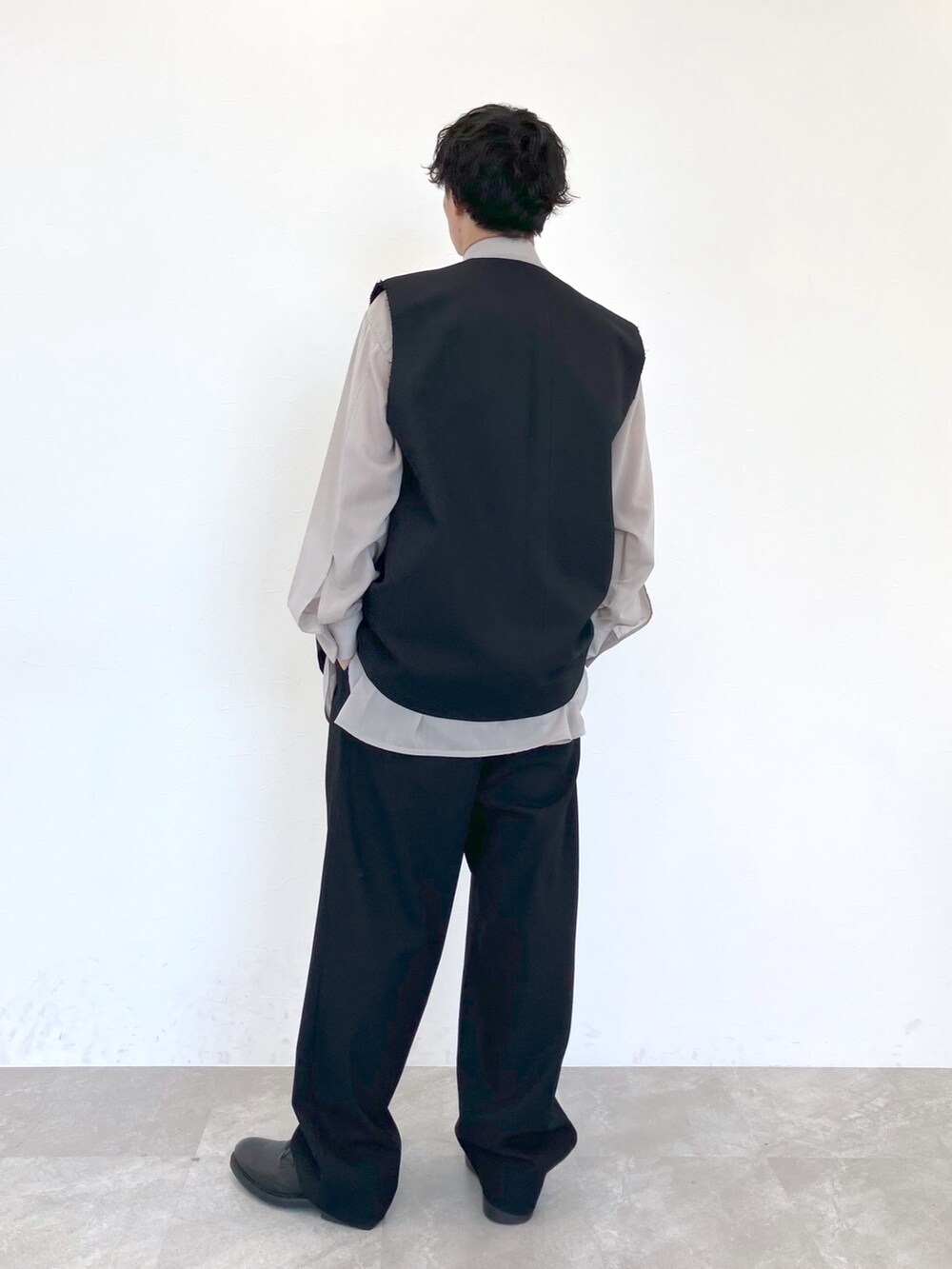 ブラック系のベスト、ベージュ系のシャツ/ブラウス、ブラック系のスラックスを着用したメンズの春コーディネートの4枚目の写真