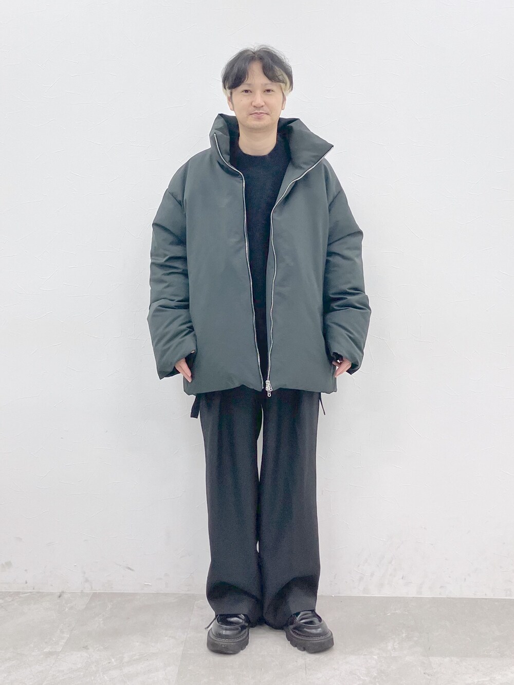 グレー系のダウンジャケット/コート、ブラック系のニット/セーター、ブラック系のその他パンツを着用したメンズの秋コーディネートの4枚目の写真