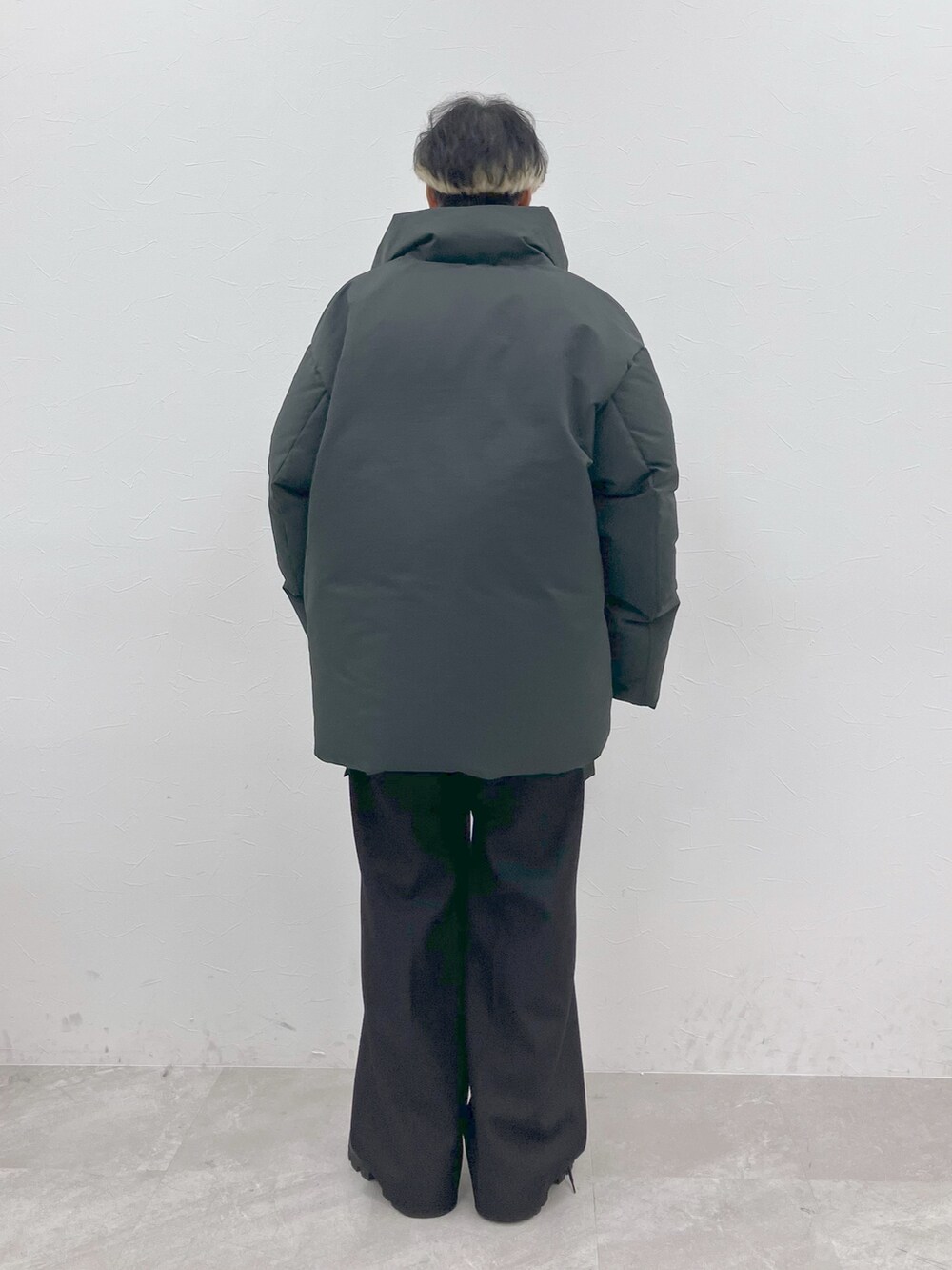 グレー系のダウンジャケット/コート、ブラック系のニット/セーター、ブラック系のその他パンツを着用したメンズの秋コーディネートの6枚目の写真