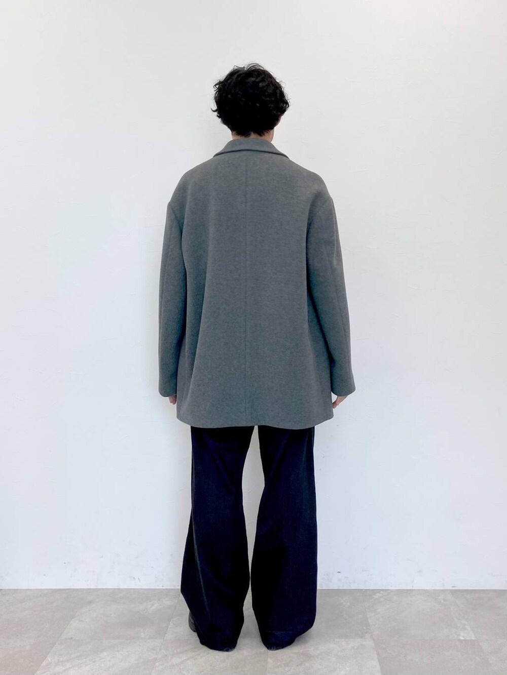 グレー系のステンカラーコート、ブラック系のデニムパンツ、ブラック系のデニムパンツを着用したメンズの秋コーディネートの7枚目の写真