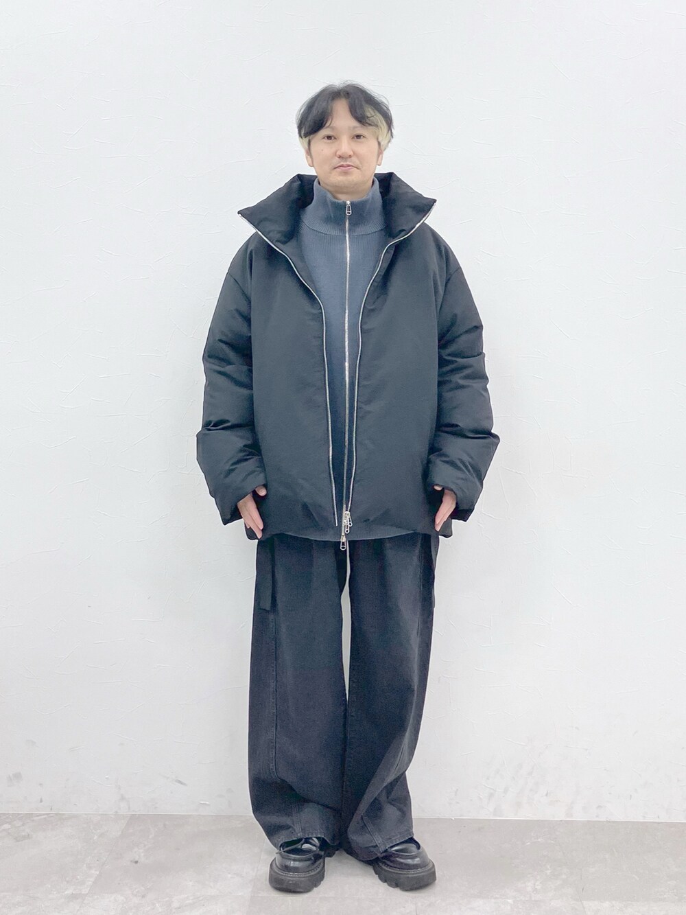 ブラック系のダウンジャケット/コート、グレー系のカーディガン/ボレロ、ブラック系のデニムパンツを着用したメンズの秋コーディネートの4枚目の写真