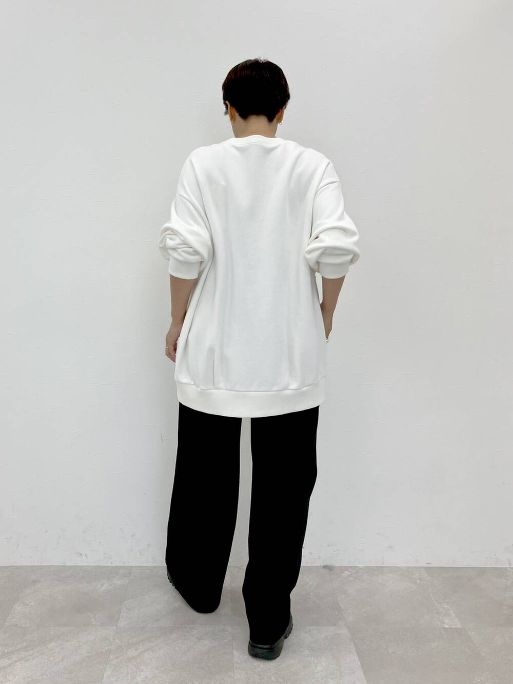 ホワイト系のスウェット、ブラック系のスラックス、ブラック系のその他パンツを着用したレディースの秋コーディネートの3枚目の写真