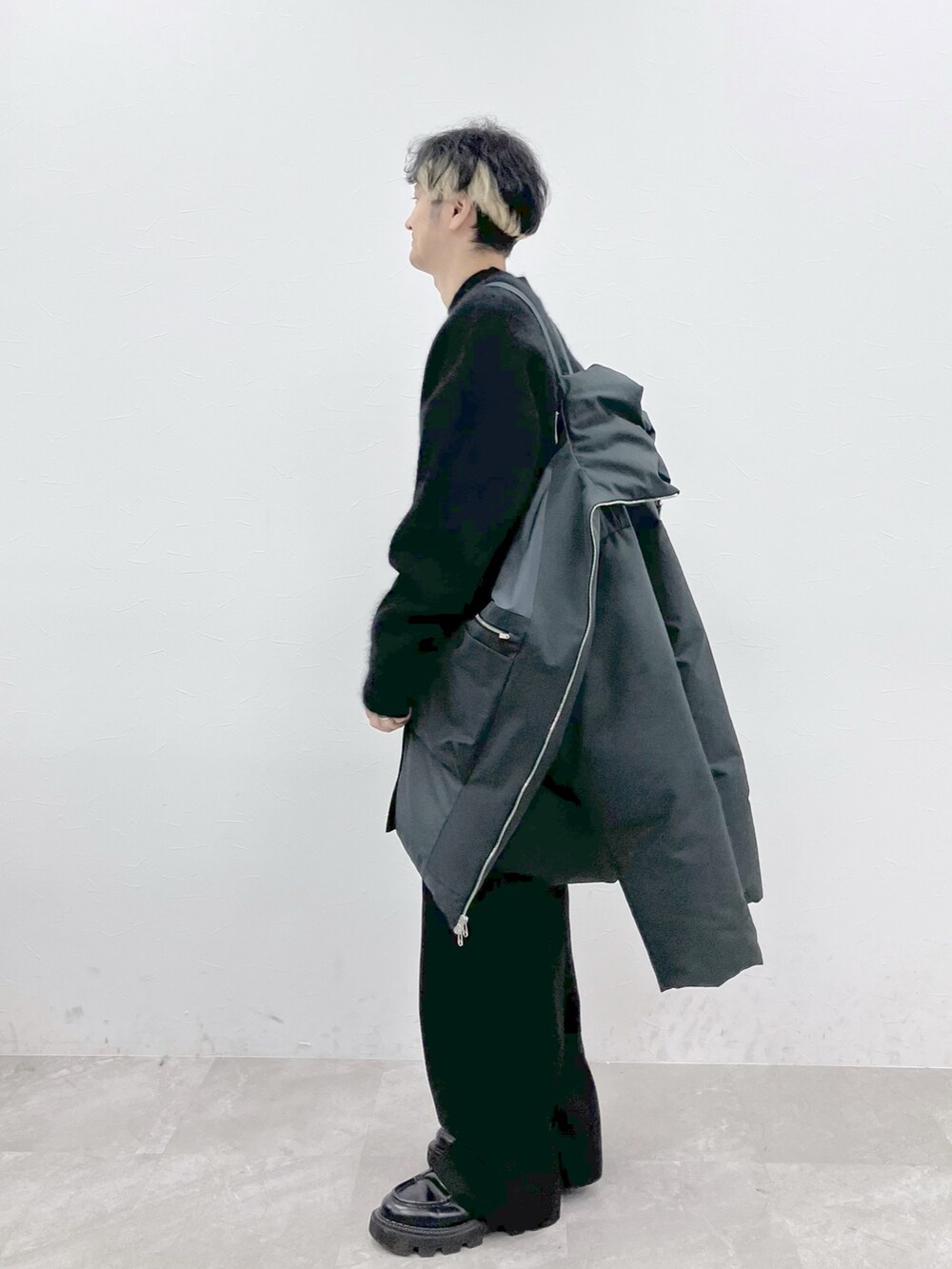 グレー系のダウンジャケット/コート、ブラック系のニット/セーター、ブラック系のその他パンツを着用したメンズの秋コーディネートの7枚目の写真