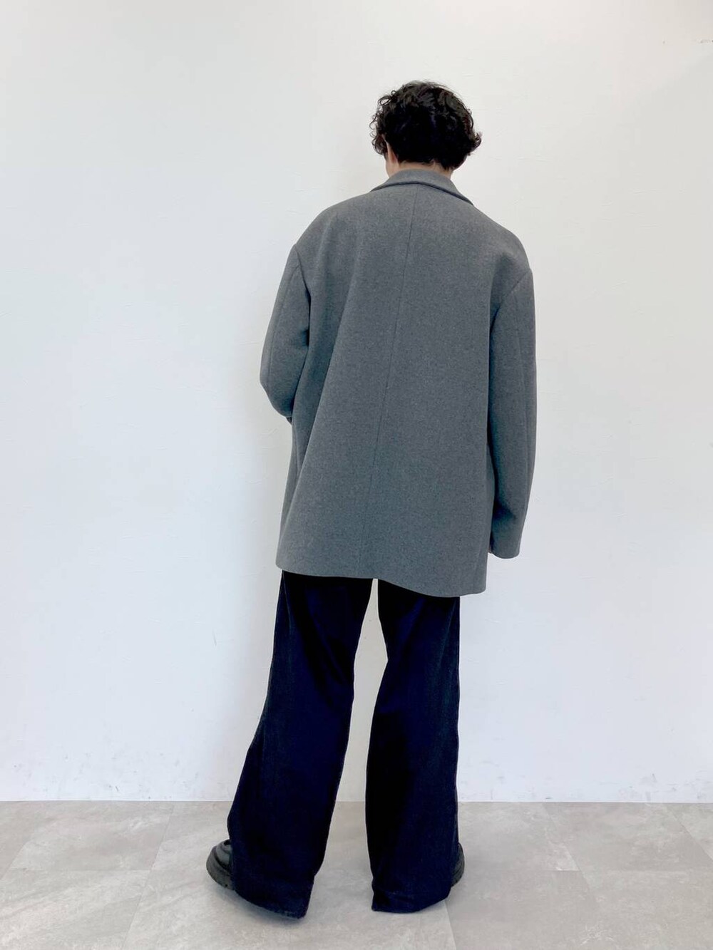 グレー系のステンカラーコート、ブラック系のデニムパンツ、ブラック系のデニムパンツを着用したメンズの秋コーディネートの4枚目の写真
