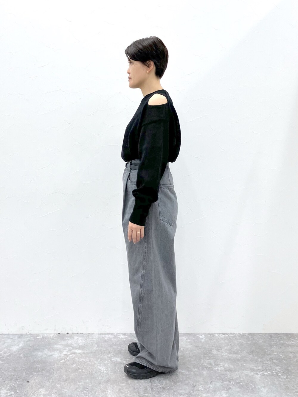 ブラック系のニット/セーター、グレー系のデニムパンツを着用したレディースの春コーディネートの6枚目の写真