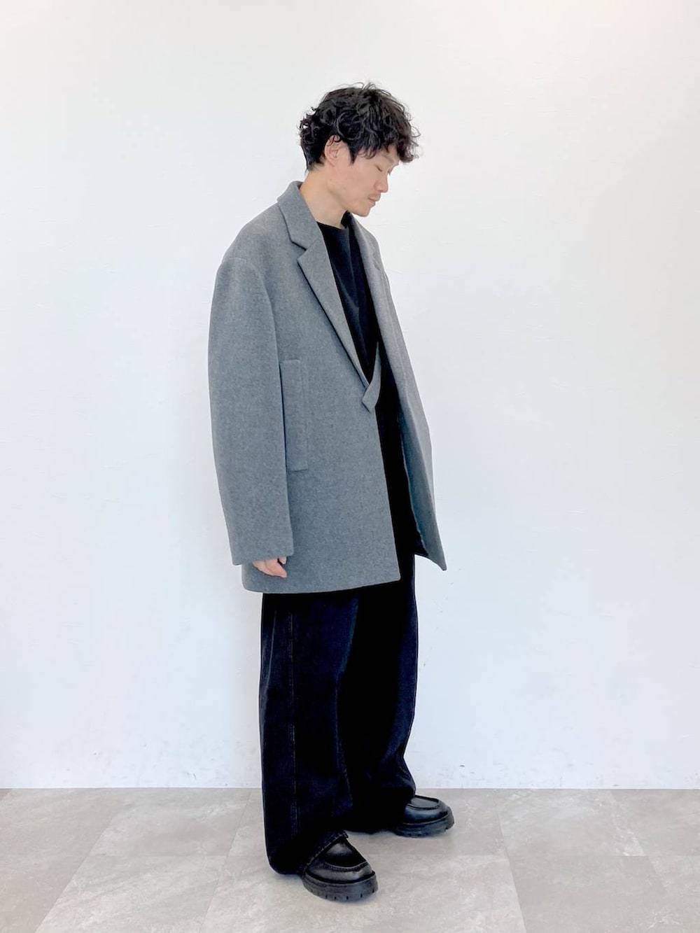 グレー系のステンカラーコート、ブラック系のデニムパンツ、ブラック系のデニムパンツを着用したメンズの秋コーディネートの3枚目の写真