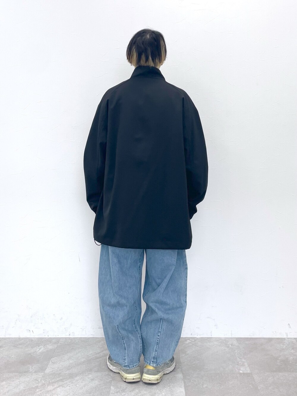 ブラック系のブルゾン、ベージュ系のトップス、ブルー系のデニムパンツを着用したメンズの冬コーディネートの8枚目の写真