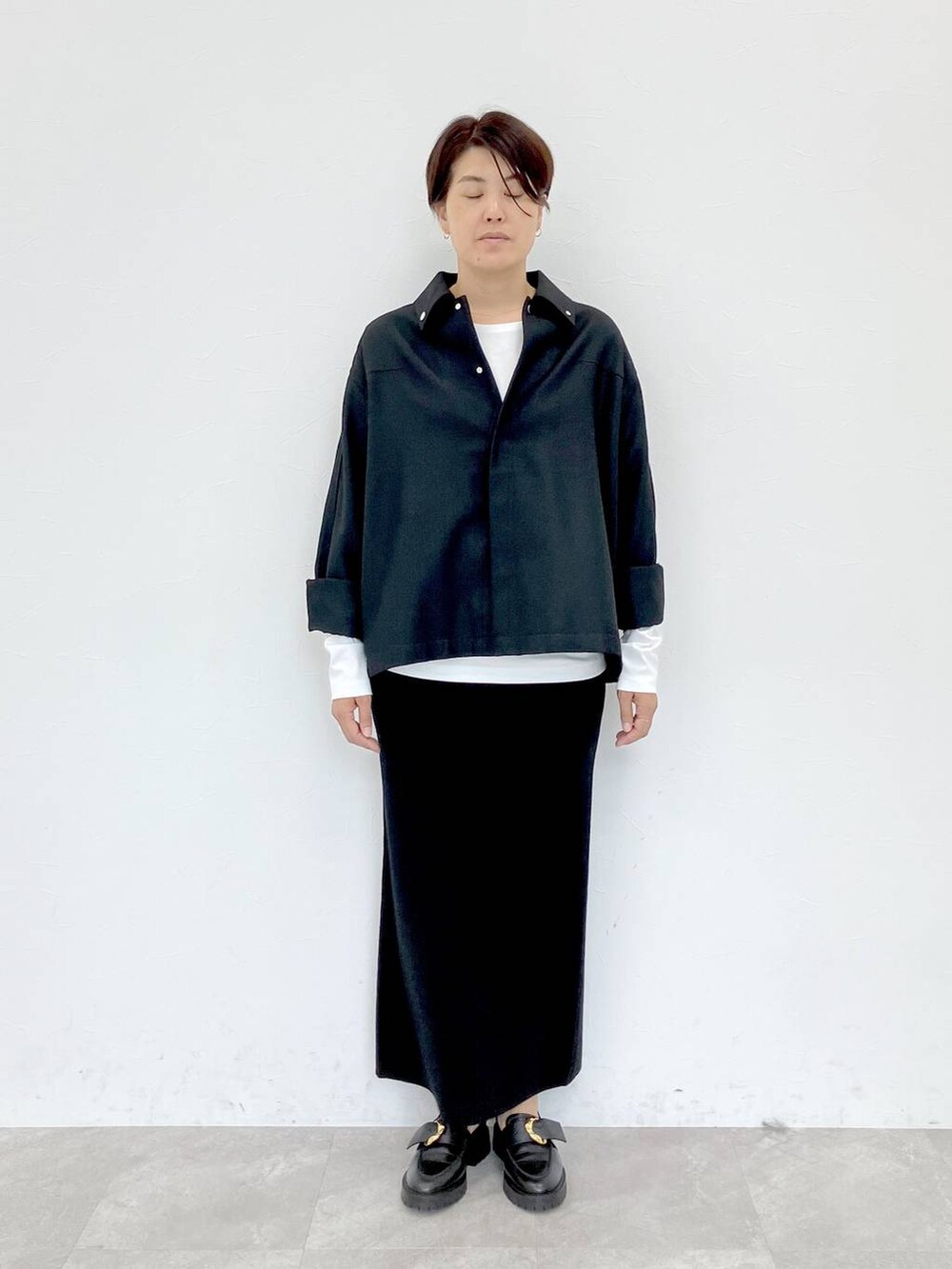 ブラック系のその他アウター、ホワイト系のTシャツ/カットソー、ブラック系のスカートを着用したレディースの秋コーディネートの5枚目の写真