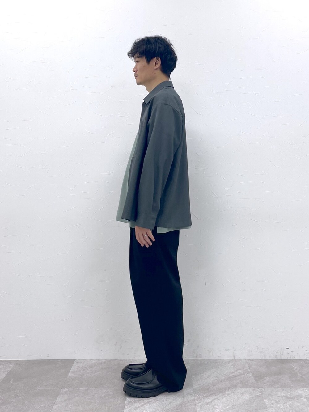グレー系のブルゾン、ブラック系のスラックスを着用したメンズの冬コーディネートの9枚目の写真