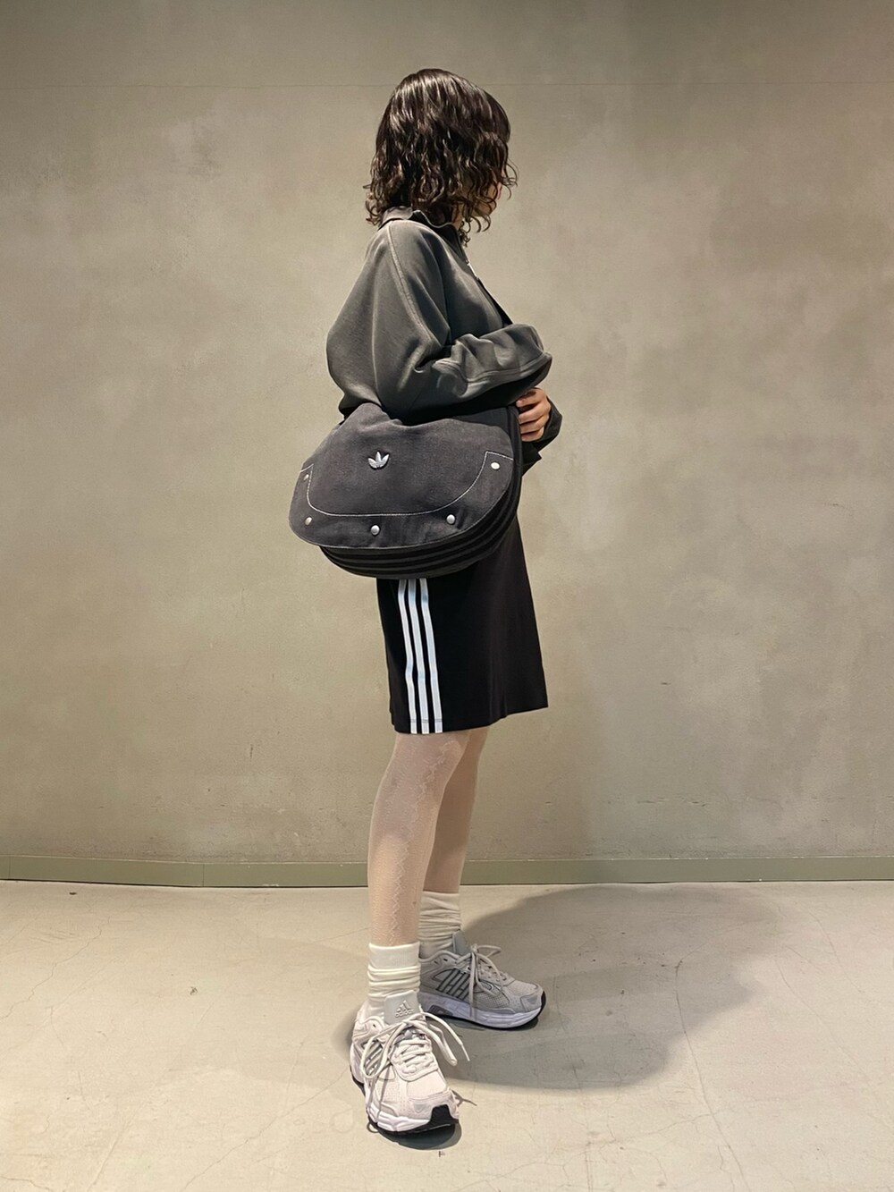 グレー系のスニーカー、ブラック系のショルダーバッグ、ブラック系のスウェットを着用したレディースの春コーディネートの2枚目の写真