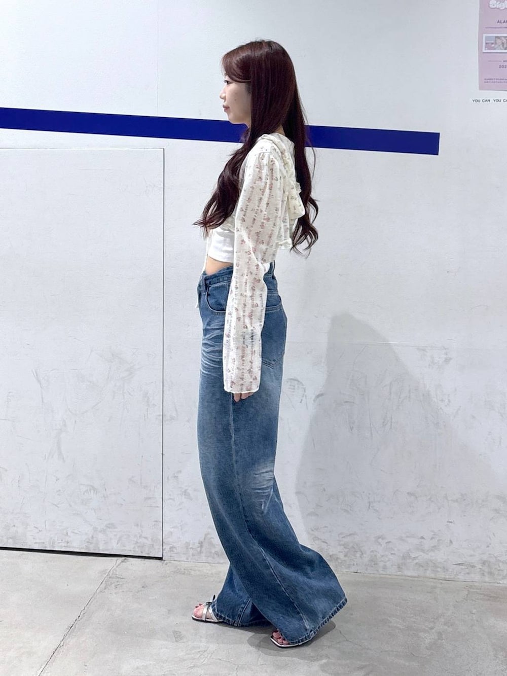 シルバー系のサンダル、ブルー系のデニムパンツ、ホワイト系のカーディガン/ボレロを着用したレディースの夏コーディネートの3枚目の写真