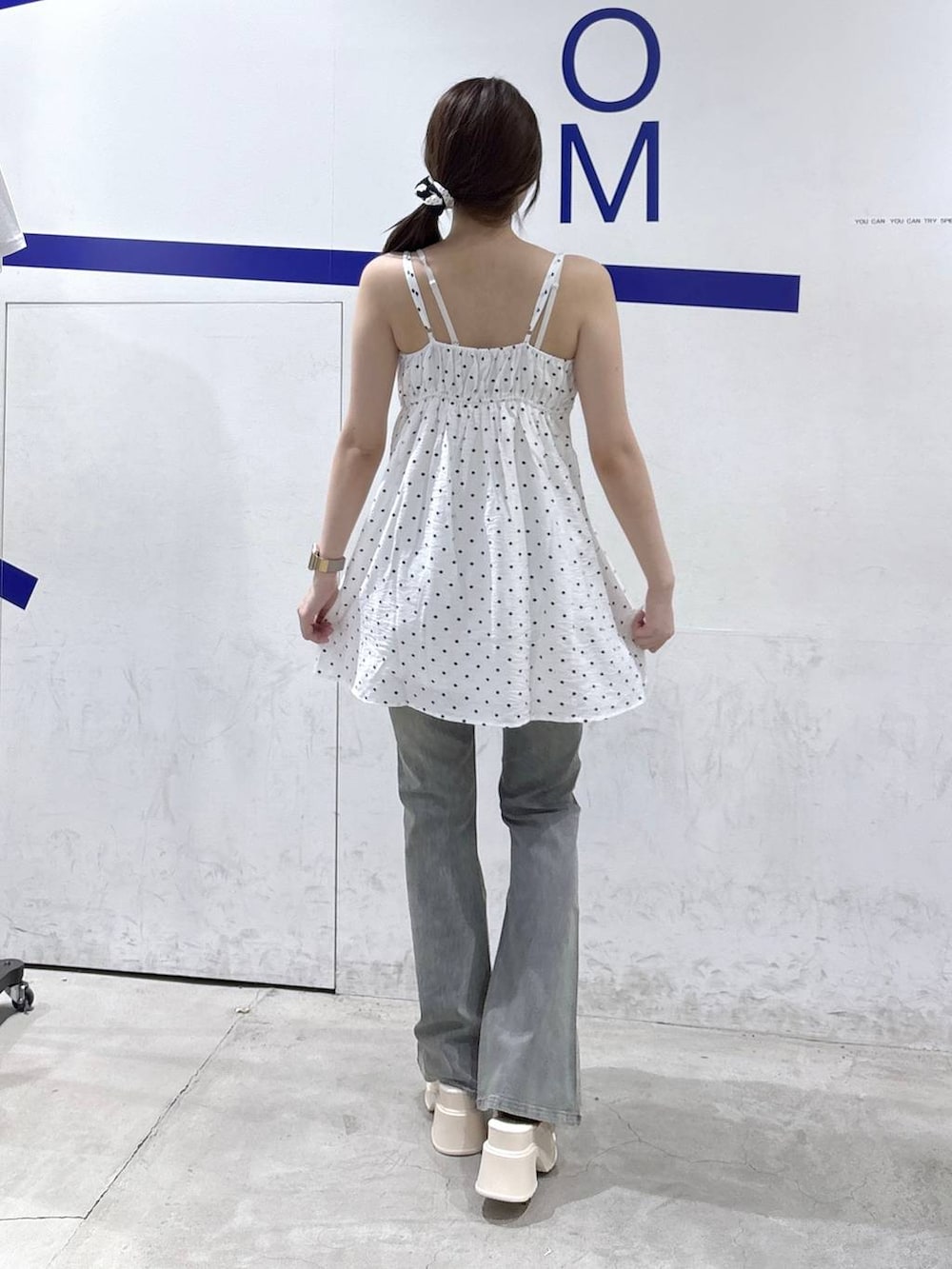 ホワイト系のサンダル、ホワイト系のワンピース、ブルー系のデニムパンツを着用したレディースの夏コーディネートの4枚目の写真